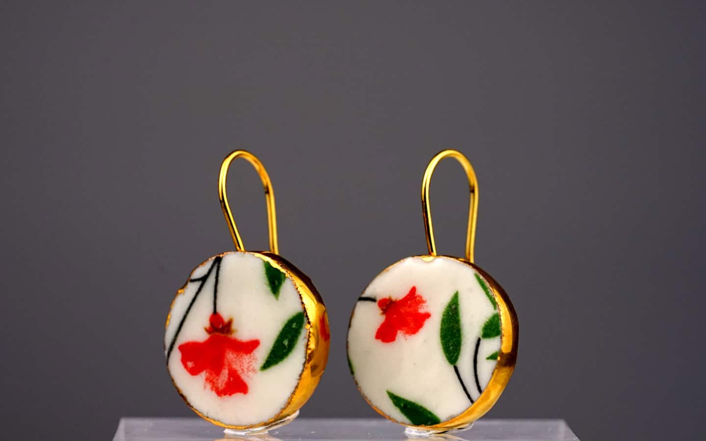 Eine tiefrote, getupfte Rose mit zarten grünen Blättern, als wäre sie gerade frisch gepflückt. Sie verkörpert Eleganz und die zeitlose Schönheit klassischer Blumenmalerei.